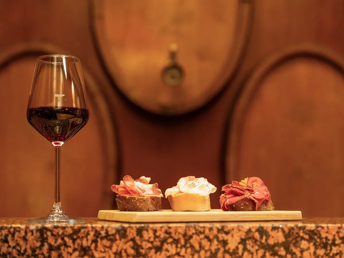 Calice di vino rosso accompagnato da spunciotti